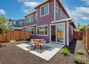 Thumbnail 26 of 30 - a patio with a table and chairs in front of a house