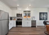 Thumbnail 11 of 30 - a kitchen with white cabinets and stainless steel appliances