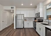 Thumbnail 13 of 30 - a renovated kitchen with white cabinets and stainless steel appliances