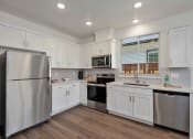 Thumbnail 12 of 30 - a kitchen with white cabinets and stainless steel appliances