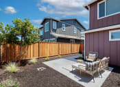 Thumbnail 9 of 30 - a patio with two chairs and a table in front of a house