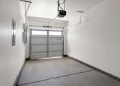 Thumbnail 10 of 30 - a garage door is in the corner of a white room with a concrete floor