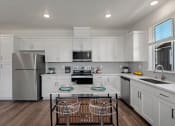 Thumbnail 3 of 30 - a kitchen with white cabinets and stainless steel appliances