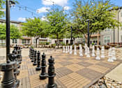 Thumbnail 30 of 33 - A giant chess board with black and white pieces in the middle of a park.