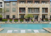 Thumbnail 23 of 33 - A large stone building with a pool in front.