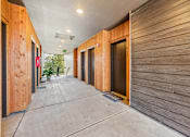 Thumbnail 22 of 28 - A long hallway with wooden walls and doors.