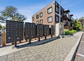 Thumbnail 20 of 28 - A modern building with a row of mailboxes in front of it.