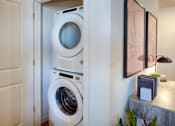 Thumbnail 18 of 35 - A white washing machine is in a small room.