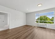 Thumbnail 9 of 21 - A room with a window overlooking a green area.