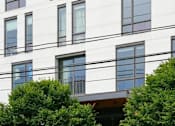 Thumbnail 33 of 35 - A modern building with white walls and dark windows.