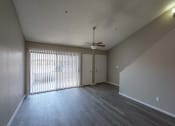 Thumbnail 21 of 36 - an empty living room with a ceiling fan and sliding glass doors