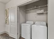 Thumbnail 4 of 33 - A laundry room with two washing machines and a dryer.