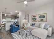 Thumbnail 3 of 33 - A living room with a blue chair and a white couch.
