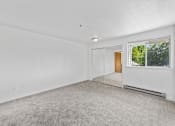 Thumbnail 15 of 25 - A white room with a carpeted floor and a window.
