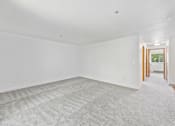 Thumbnail 10 of 25 - A room with a carpeted floor and white walls.