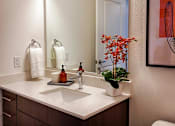 Thumbnail 32 of 35 - A bathroom with a white sink and a mirror.