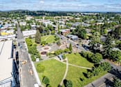 Thumbnail 23 of 27 - Arts Plaza Gresham Oregon Apartments neighborhood A view of a town from above, with buildings, roads, and a park visible.