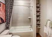 Thumbnail 21 of 35 - A white bathroom with a tub, toilet, and sink.
