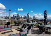 Thumbnail 23 of 32 - a roof top bar with a view of the seattle skyline