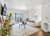 Thumbnail 11 of 38 - A living room with a white couch, a coffee table, and a large window.