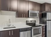 Thumbnail 16 of 28 - a kitchen with stainless steel appliances and wooden cabinets