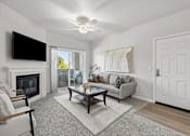 Thumbnail 24 of 28 - A living room with a fireplace and a television above it.