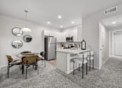 Thumbnail 26 of 28 - A kitchen with a table and chairs in the middle of the room.
