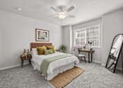 Thumbnail 23 of 28 - A bedroom with a bed, desk, chair, and a ceiling fan.