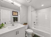 Thumbnail 28 of 28 - A white bathroom with a toilet, sink, and bathtub.