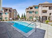 Thumbnail 12 of 28 - A swimming pool in front of apartment buildings.