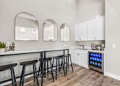 Thumbnail 18 of 28 - A kitchen with a bar area and a refrigerator with a blue light on it.