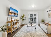 Thumbnail 10 of 38 - A living room with a large painting on the wall and a white sofa.