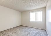 Thumbnail 26 of 29 - A room with a window and carpeted floor.