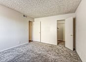 Thumbnail 24 of 29 - A room with carpeted floor and white walls with three doors.