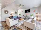 Thumbnail 19 of 29 - A living room with a blue couch and a white chair.