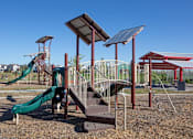 Thumbnail 7 of 35 - A playground with a green slide and a red and white striped slide.