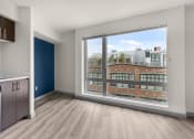 Thumbnail 7 of 28 - an empty living room with a large window and a kitchen