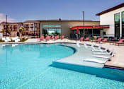 Thumbnail 11 of 35 - Pool with white lounge chairs in the water.