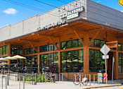 Thumbnail 26 of 35 - A street view of New Seasons Market with a bicycle parked in front.