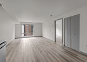 Thumbnail 20 of 28 - an empty living room with white walls and wood flooring