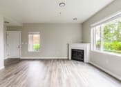 Thumbnail 10 of 43 - an empty living room with a fireplace and two windows