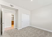 Thumbnail 51 of 58 - a bedroom with white walls and carpet and a door to a bathroom