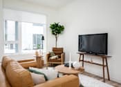 Thumbnail 7 of 30 - The Wes Gresham Oregon Apartments living area with tv, chair and couch