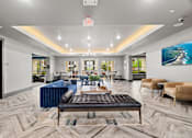 Thumbnail 14 of 33 - A spacious waiting area with a variety of seating options and a large painting on the wall.