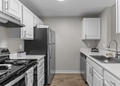 Thumbnail 8 of 32 - an empty kitchen with white cabinets and stainless steel appliances