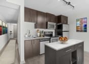 Thumbnail 2 of 28 - an apartment kitchen with stainless steel appliances and wooden cabinets