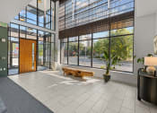 Thumbnail 6 of 21 - a lobby with large windows and a wooden bench