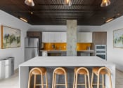 Thumbnail 3 of 21 - a kitchen with a white counter top and four stools