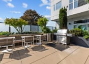 Thumbnail 4 of 21 - a patio with tables and chairs and a grill