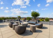 Thumbnail 11 of 21 - a seating area on the roof of a building with tables and chairs